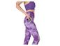 Frau in lila Leggings und Sport-BH, die ein Telefon in die Seitentasche steckt.