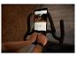 Person benutzt ein Heimtrainer mit Tablet, das Trainingsdaten und eine Straßenansicht anzeigt.