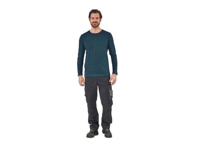 Mann trägt ein dunkelblaues Langarmshirt und eine graue Arbeitshose.