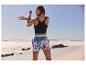 Sportlerin in Top und Shorts am Strand.