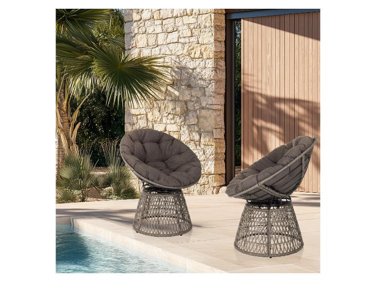 Zwei graue Gartenstühle mit Kissen am Pool, vor einer Steinwand und Palmen.