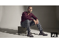 Mann in weinrotem V-Ausschnitt-Pullover, grauer Hose und grauen Chelsea-Boots aus Wildleder.