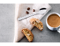 Kaffee mit Biscotti und Kaffeebohnen auf hellem Tuch
