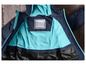 Eine blaue Jacke mit türkisfarbenem Futter und einem Namensschild.