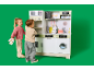 Kinder spielen mit einer Spielzeugküche aus Holz vor grünem Hintergrund.