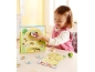 Ein kleines Mädchen spielt ein Kinderbrettspiel mit einem Bienenstock.