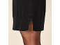 Schwarzes Strickkleid mit Schlitz und schwarze Strumpfhose.