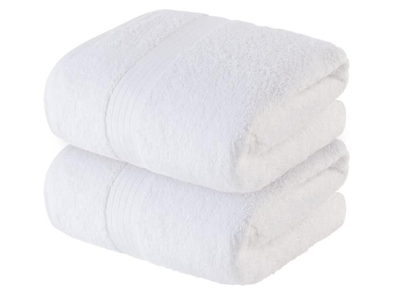 Zwei weiche, weiße Handtücher, aufeinander gestapelt.