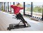 Eine Frau trainiert auf einem Rückentrainer in einem hellen Fitnessstudio.