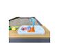 Ein Sandtisch aus Holz mit Spielzeugspüle und Plastikfrüchten.