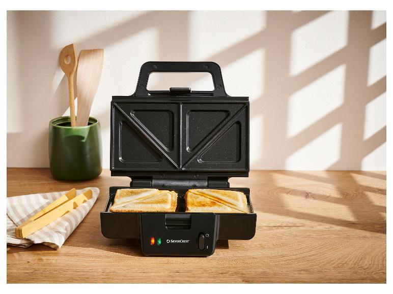 Offener SilverCrest Sandwichmaker mit zwei Toastscheiben auf einer Holztheke.