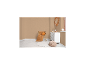 Gemütliches Zimmer mit goldenem Stuhl, orangefarbener Decke, weißer Kommode und rundem Teppich.