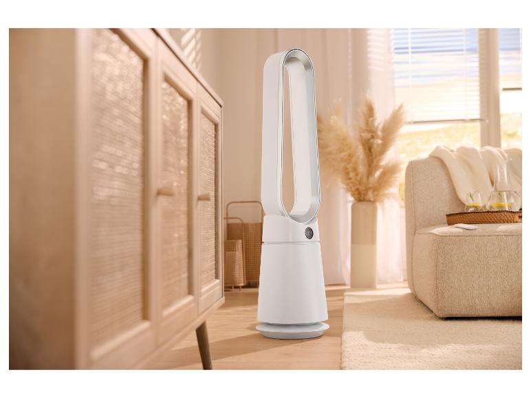 Weißer Turmventilator in einem Wohnzimmer mit Holzmöbeln und Sofa.