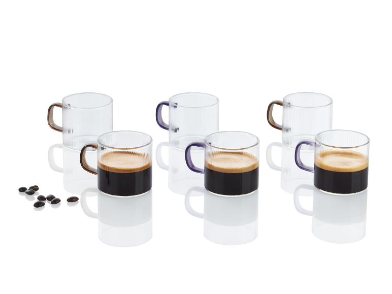 Espresso in gläsernen Tassen mit violetten Henkeln.