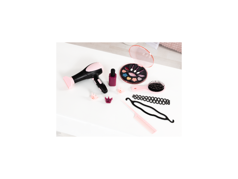 Spielzeug-Haartrockner, Make-up-Palette, Haarbürste und Styling-Zubehör auf einer weißen Oberfläche.