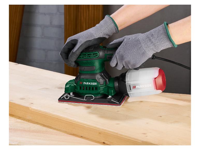 Person mit Handschuhen schleift Holz mit einem grünen und schwarzen Parkside Schwingschleifer.