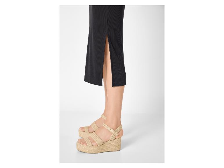 Frau in schwarzem Rock und Espadrille-Plateausandalen