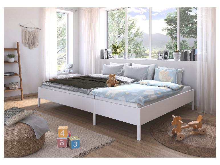 Kinderzimmer mit zwei weißen Einzelbetten, einem Holzregal und Spielzeug auf dem Boden.