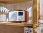 Holzradio im Retro-Stil auf einem Regal mit Uhrzeit auf dem Display.