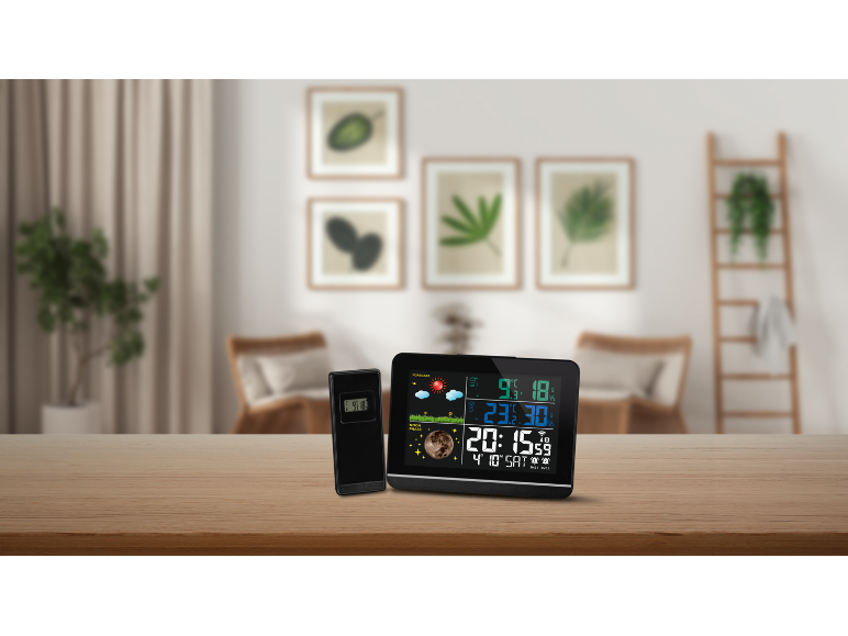 Moderne digitale Uhr und Thermometer auf einem Holztisch.