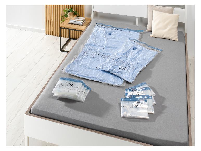 MAX Vakuumbeutel für Kleidung und Decken auf einem Bett.
