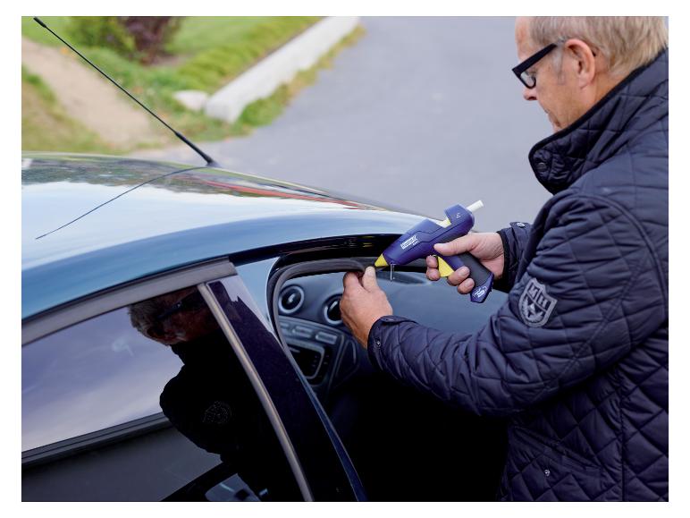 Mann klebt eine Autotür mit einer LIVARNO® CG270 Akku-Klebepistole.