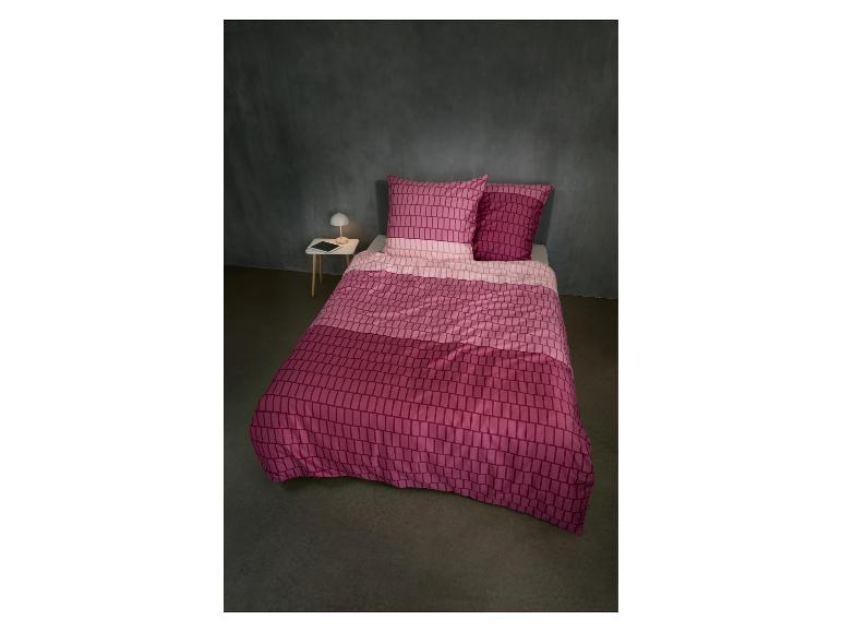 Rosa gemusterte Bettwäsche in einem Schlafzimmer mit Nachttisch