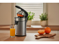 Elektrische Zitruspresse mit einem Glas Orangensaft auf der Küchenarbeitsplatte