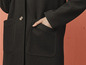 Schwarzer Wollmantel mit Taschen.