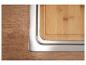 Arbeitsplatte aus Holz und Schneidebrett aus Bambus, integriert in eine Edelstahlspüle.