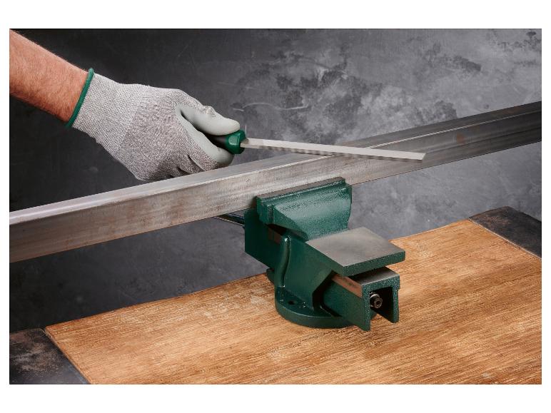 Eine Hand, die eine Feile verwendet, um Metall in einem Schraubstock zu bearbeiten.