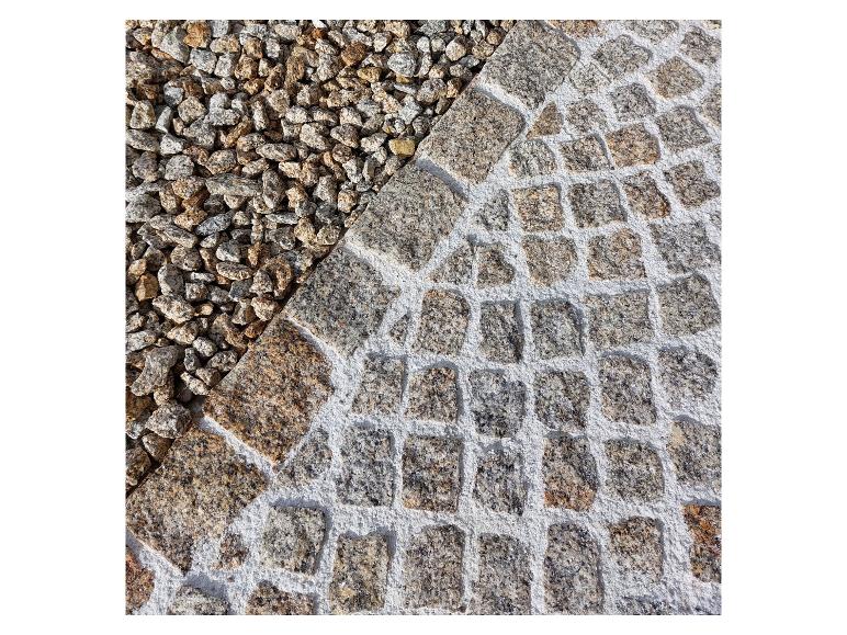 Nahaufnahme einer gepflasterten Fläche mit Kies und Kopfsteinpflaster in Bogenmuster.