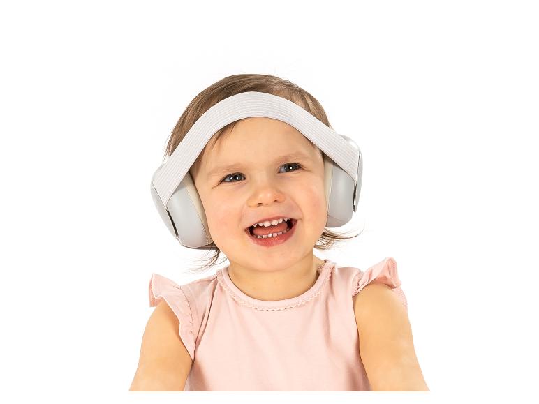 Ein lächelndes Baby trägt einen Gehörschutz.