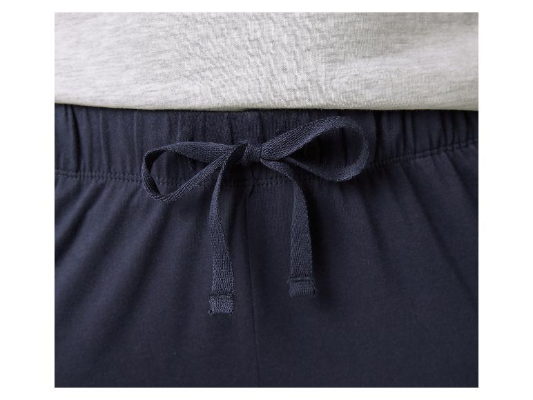 Nahaufnahme einer dunkelblauen Pyjamahose mit Kordelzug und einem hellgrauen T-Shirt.
