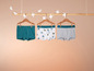Drei Jungen-Boxershorts, eine einfarbig grün, eine mit Muster und eine grau.