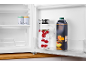 Offener Kühlschrank mit einer Kanne Himbeerwasser und einem Karton Pfirsichsaft.