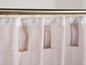 Beige Gardinen mit weißem Futter, an einer silbernen Stange aufgehängt.