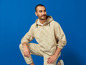 Ein Mann in einer beigefarbenen Lidl-Jacke und Hose.