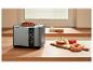 Toaster mit Vollkornbrot, Bagels mit Frischkäse und Tomaten auf einer Holztheke.