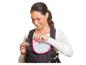 Lächelnde Frau passt eine schwarze Babytrage mit einem grauen Lätzchen mit weißen Pfeilen an.