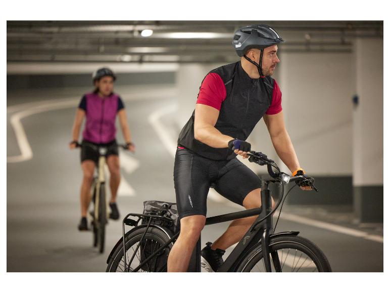 Zwei Radfahrer auf E-Bikes in einer Tiefgarage.