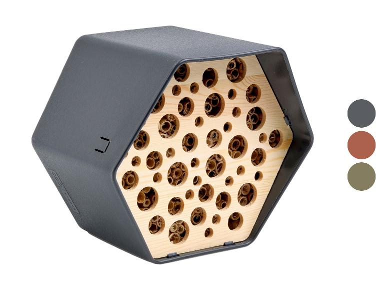 Sechseckiges Insektenhotel mit Holzinterieur und unterschiedlich großen Löchern, in Dunkelgrau.