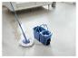 Blauer Mopp und Eimer reinigen einen Zementboden im Wohnzimmer.