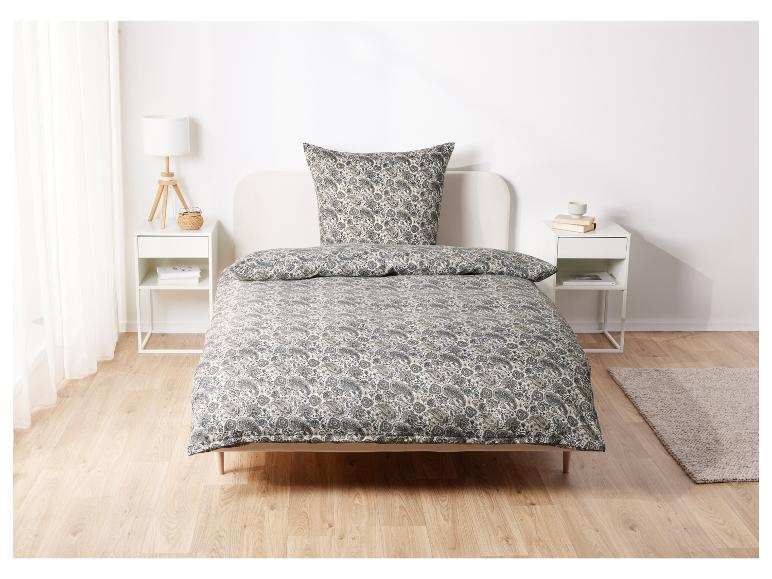 Ein Bett mit Paisley-Bettwäsche und zwei Nachttischen.