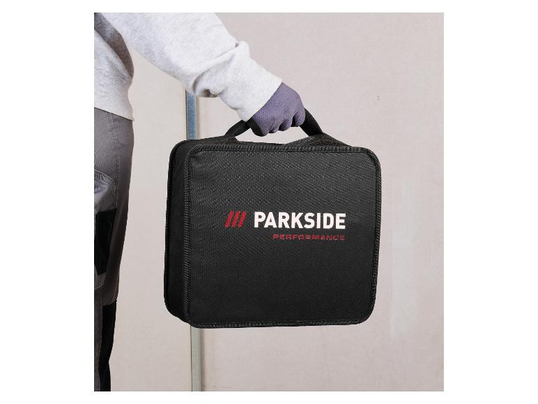 Person in Arbeitskleidung hält eine schwarze Werkzeugtasche mit rotem Logo.