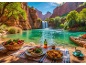 Picknick im Freien mit Brot, Gemüse und Obst vor einem wunderschönen Wasserfall.