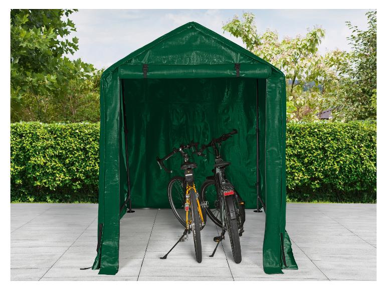 Grüner Fahrradunterstand mit zwei Fahrrädern auf einer gepflasterten Terrasse.