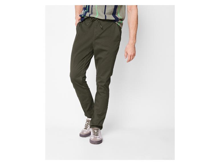 Olivengrüne Chinohose mit Kordelzug und beigen Sneakern.