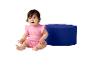 Ein Baby in einem rosa Strampler mit Sonnenmuster sitzt neben einem blauen Pouf.
