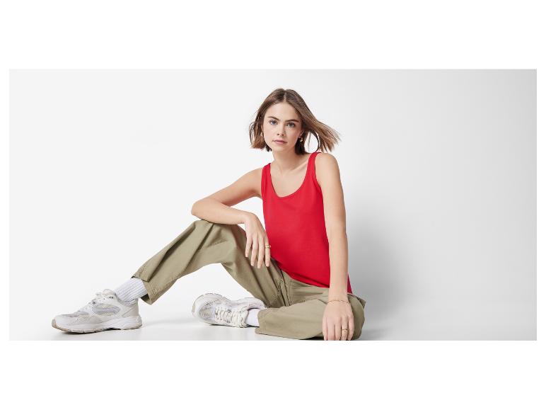 Rotes Top, Khakihose und weiße Sneaker: lässiger Look.